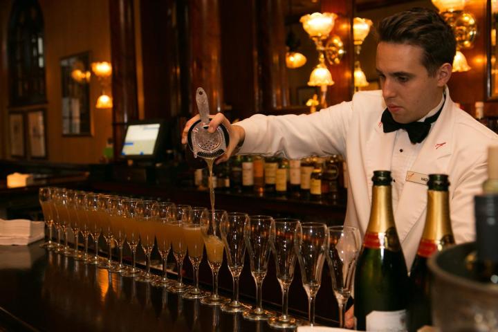 a man sitting at a table with wine glasses